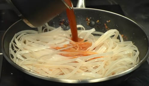 Verter la salsa sobre los fideos de Pad Thai