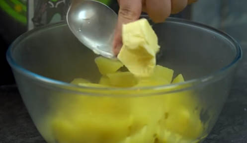 Agregar mantequilla a las patatas cocidas